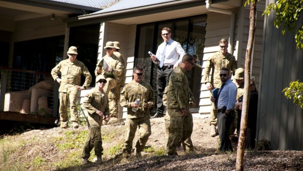 Police and ADF personnel search the Brisbane home where explosives were found. 