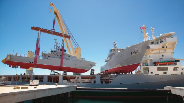Patrol boats made for the Yemeni Government are loaded onto a mother ship for transport to the Middle East.
