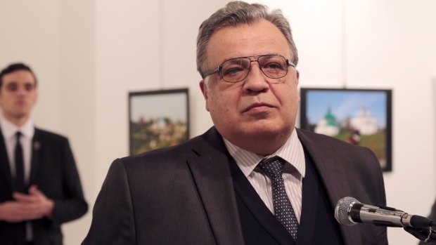 Russian Ambassador to Turkey Andrei Karlov makes an address at the gallery moments before he is shot by Mevlut Mert Altintas, seen in the background.