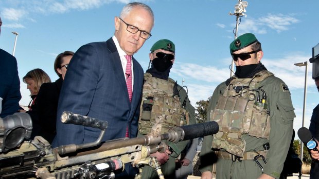 Prime Minister Malcolm Turnbull examines some military hardware during a media conference at Holsworthy Barracks on Monday.