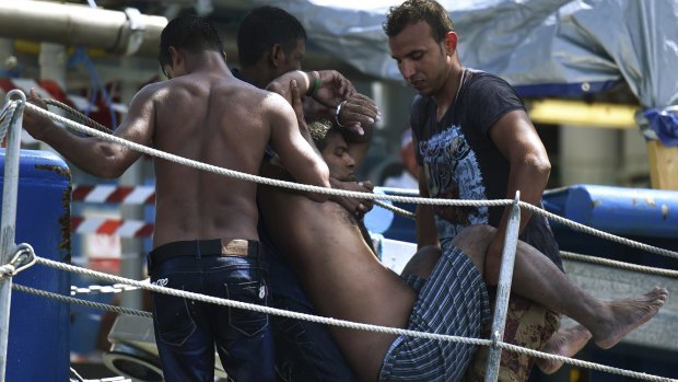 A refugee is carried up the gangway of the Swedish Coast Guard ship as it rescues 441 people; 52 people died in the hull. 