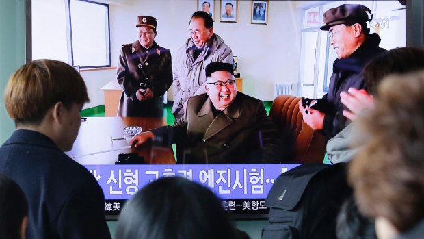 People watch a TV news program showing an image of North Korean leader Kim Jong-un at the country's Sohae launch site, at Seoul Railway station.