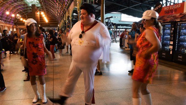 Elvis enthusiast Sean Wright (centre) dances at Central Station moments before boarding the train to Parkes for the Elvis Festival.