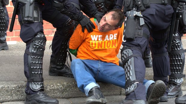 A man is detained by police.