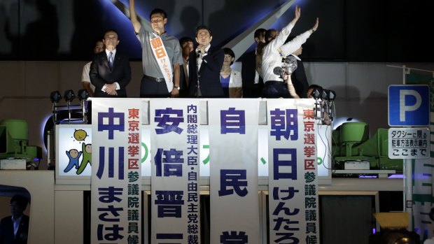 Shinzo Abe, Japan's prime minister and president of the Liberal Democratic Party, centre, speaks, as Taro Aso, Japan's deputy prime minister and finance minister, far left, looks on.