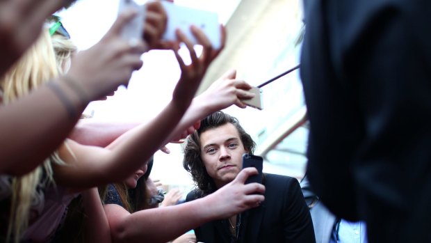 Grinning and bearing it: Harry Styles, of One Direction, is mobbed by smartphone-wielding fans at the ARIAs in Sydney.
