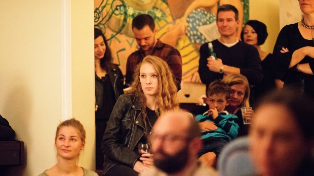 Party guests watch as Sally Seltmann performs.