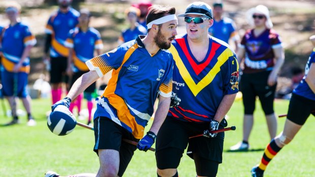 Competitors compete in Quidditch with broomsticks between their legs.