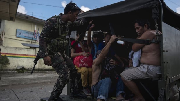 Residents who escaped from the inner city are transported to safer ground in Marawi City, southern Philippines.