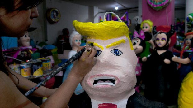 Alicia Lopez Fernandez paints a pinata depicting Donald Trump at her family's store "Pinatas Mena Banbolinos" in Mexico City in 2015.