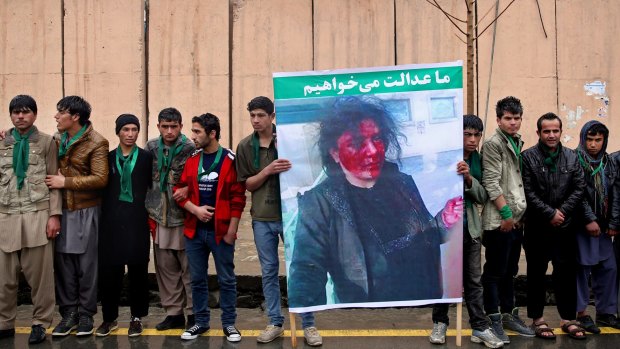 Afghan men stand in front of the supreme court in Kabul to demand justice for Farkhunda, pictured in the placard.