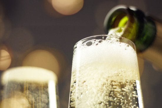 Sparkling wine being poured into glass. 