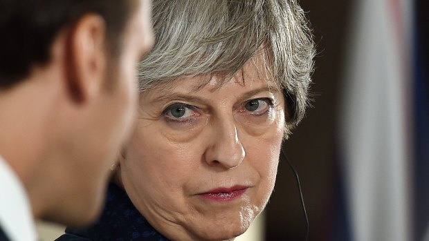 Theresa May listens at a news conference with Emmanuel Macron last week.