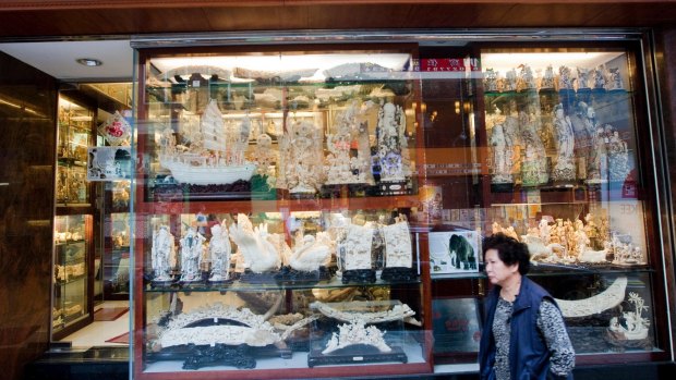 A pedestrian walks past an ivory shop in Kowloon, Hong Kong. China says it will retrain master carvers as they will no longer be able to work in the ivory industry.
