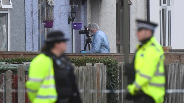 Police and forensic officers at a property which was raided. 