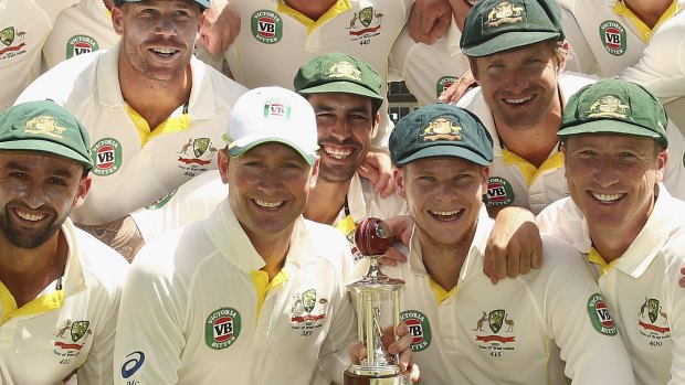 Australia players looks on as captain Michael Clarke (second from left) and vice-captain Steve Smith (second from right) hold the Frank Worrell Trophy, which their team emphatically retained as their 277-run win in the second Test in Jamaica sealed a 2:0 series victory against their hosts.