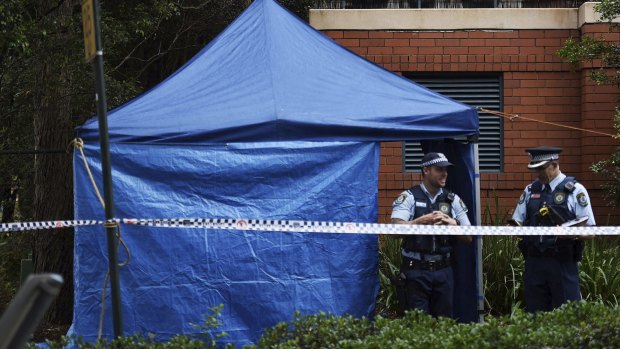 Police at the scene where a man's body was discovered in a charity clothing bin.