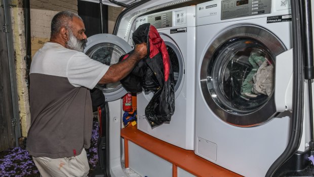 Theo Smith washes his clothes in the back of the van for free. 