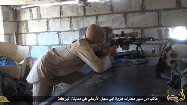 Islamic State militant sniper in position during a battle against Syrian government forces, in Deir el-Zour province, Syria.