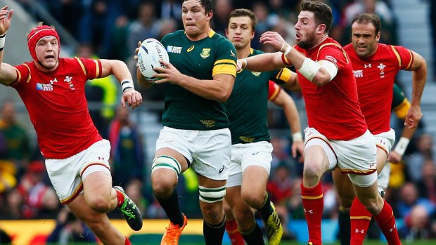 South Africa's Francois Louw is tackled by Alex Cuthbert of Wales.