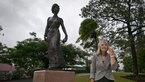 Penny Dowie stands beside her Uncle John Dowie's  sculpture of the Queen.