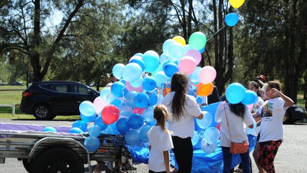Lateesha Nolan's children and family release blue balloons in her honour at a memorial service at Sandy Beach. 