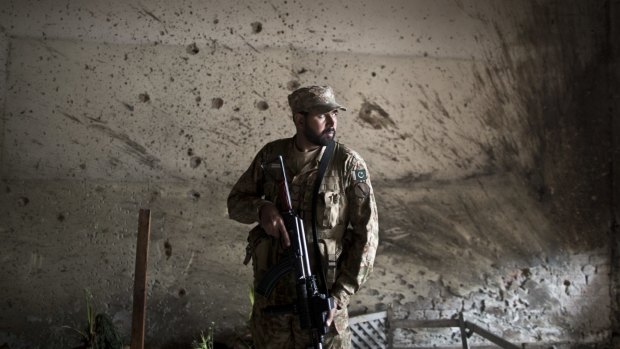 A Pakistani army officer stands guard inside the school in Peshawar that was attacked last week.
