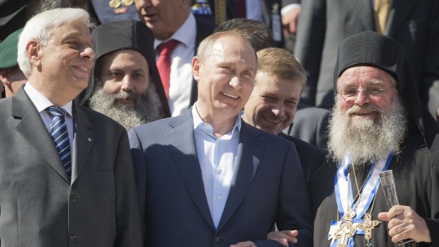 Russian President Vladimir Putin (centre) with Greek President Prokopis Pavlopoulos (left) in Greece on Saturday. 