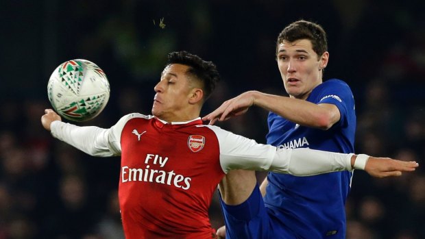 Arsenal's Alexis Sanchez, left, challenges for the ball with Chelsea's Andreas Christensen.