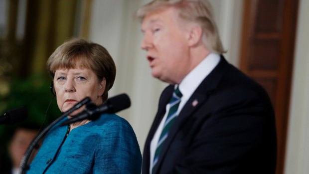 German Chancellor Angela Merkel listens as President Donald Trump speaks during their joint news conference.