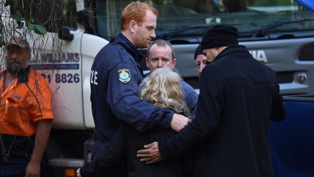 Detective Senior Constable Scott Craddock (left) and Detective Chief Inspector Gary Jubelin embrace Faye Leveson after bones were found. 