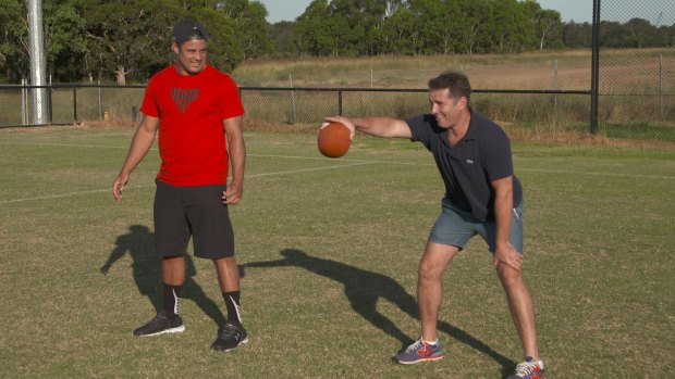 Game time: Stefanovic puts Hayne through his paces at American football.
