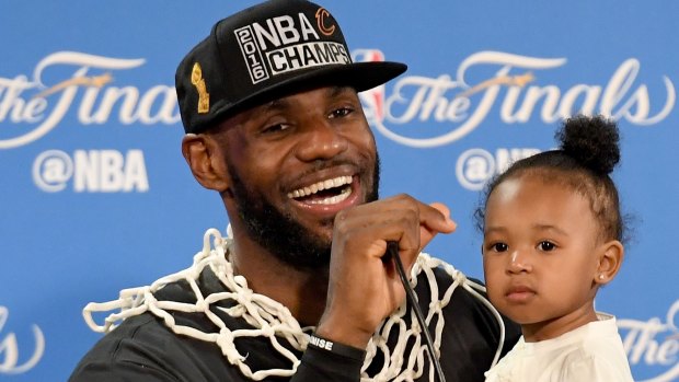 The King and his princess: LeBron James holds his daughter Zhuri during the post-game press conference.