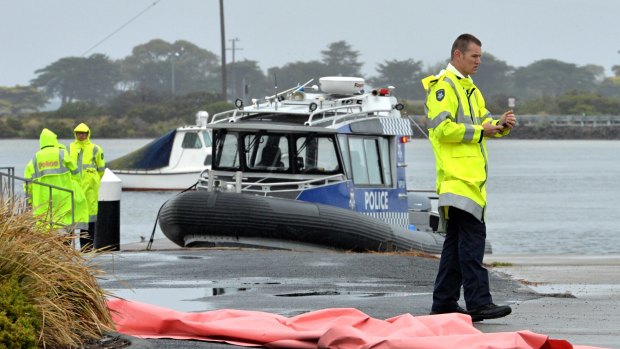 A police boat recovers three bodies after a plane crash at Ocean Grove.