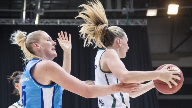 Lauren Jackson of the Canberra Capitals and Penny Taylor of the Dandenong Rangers vie for the ball.