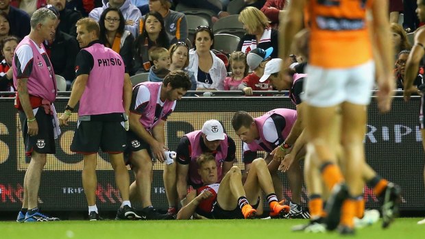 Nick Riewoldt is attended to by trainers after taking a heavy knock during the match against the Greater Western Sydney Giants on Sunday.