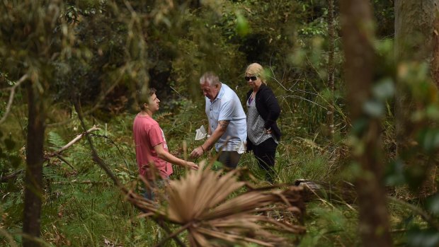 Mark Leveson, centre, with his wife Faye Leveson and son Peter Leveson flag spots in the Royal National Park during the search for Matthew Leveson's body. 