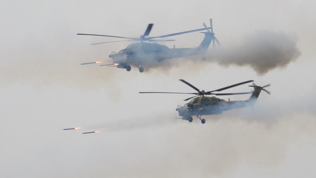 Russian military helicopters fire during a military exercise at a training ground at the Luzhsky Range near St. Petersburg, Russia.