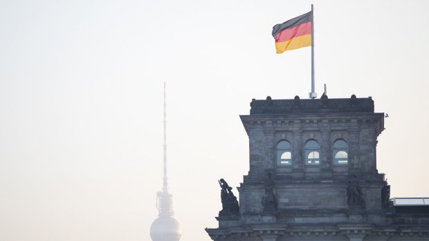 A German national flag flies above the Reichstag in Berlin, Germany.