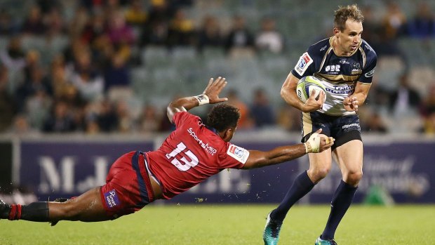 Andrew Smith of the Brumbies evades the tackle of Samu Kerevi of the Reds.