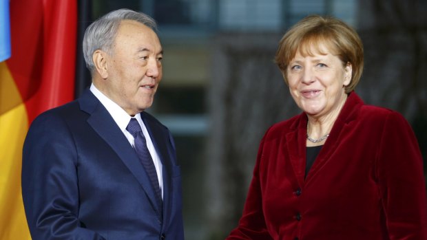 Kazakh President Nursultan Nazarbayev is greeted by German Chancellor Angela Merkel at the Chancellery in Berlin on Friday.