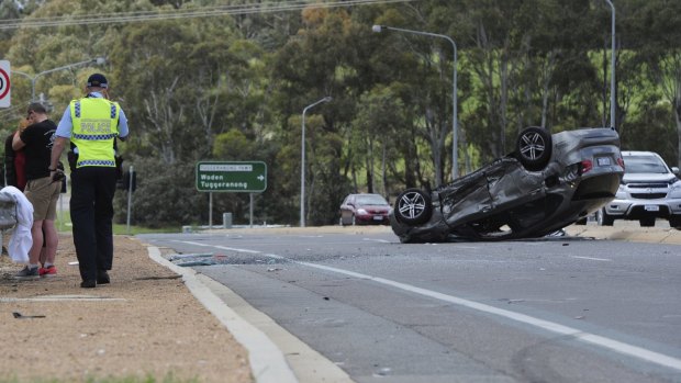 The vehicle on its roof on the Cotter Road overpass on the Tuggeranong Parkway. 
