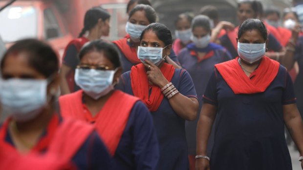 Women wear masks during an anti-pollution protest in New Delhi on Sunday.