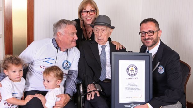 Israel Kristal with, from left to right, grandchildren Nevo and Omer, son Heim Kristal, and daughter Shula Kuperstoch, received the certificate from Guinness World Record's Marco Frigatti, right.