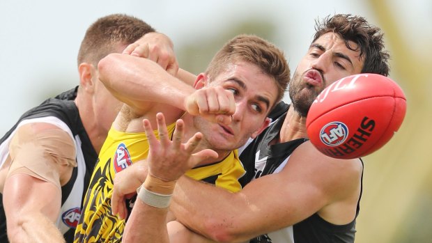 Tough in close: Anthony Miles of the Tigers is tackled by Alex Fasolo.