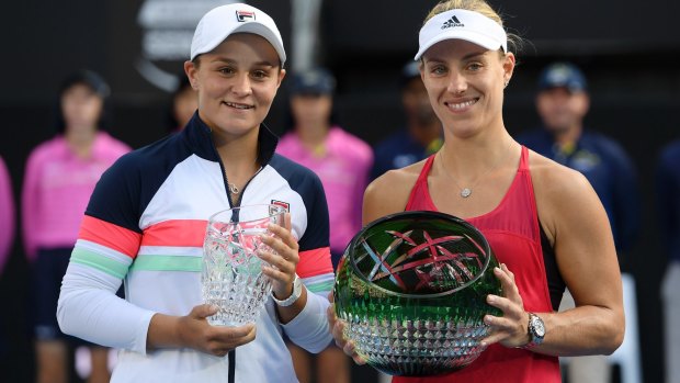 Last women standing: Ash Barty and Angelique Kerber pose with the runner-up and winner's trophies.