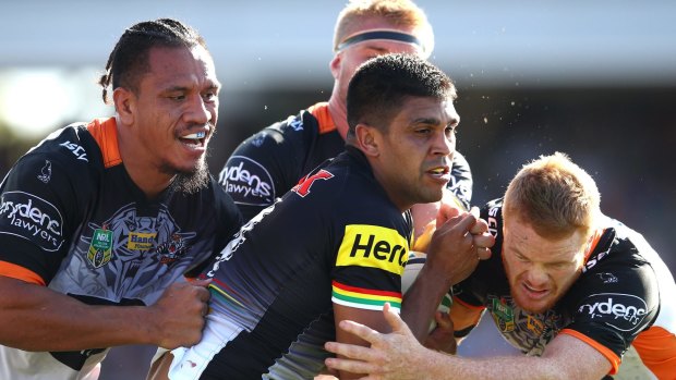 Through the middle: Tyrone Peachey is wrapped up by three Tigers defenders.