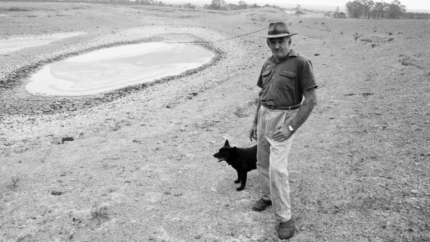 A Queensland farmer and his dog stand alongside a dried up dam in November 1994. 