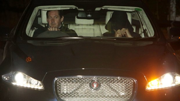 A man thought to be Jose Mourinho, right, covers his face as he is driven from Chelsea's training ground on Friday.