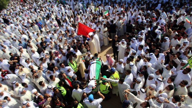 Mourners carry the body of one of the victims of the Al-Imam Al-Sadeq mosque bombing, during a mass funeral at Jaafari cemetery in Kuwait City.